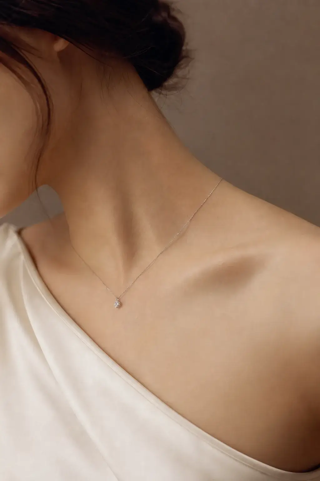 One fine white gold diamond pendant worn alone at the collarbone