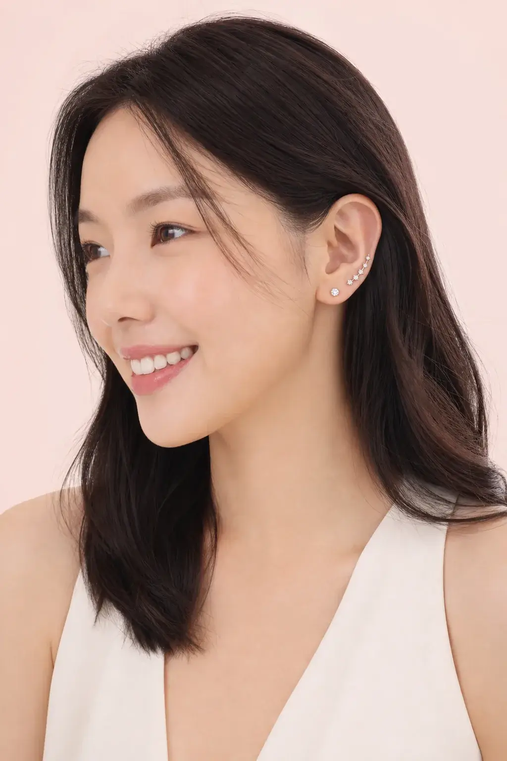 A white gold natural diamond stud and ear climber shown with hair tucked behind the ear
