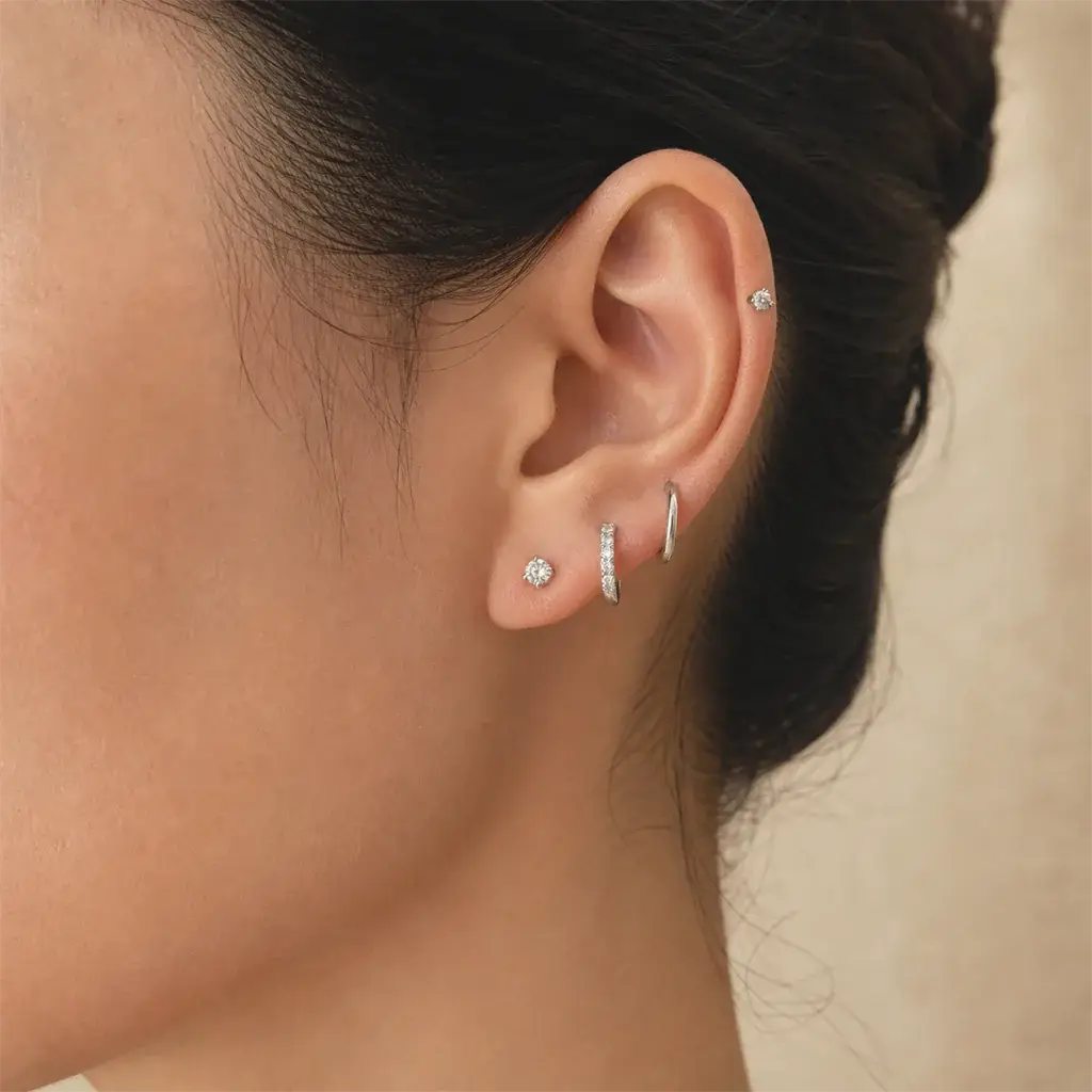 Diamond studs, huggies and hoops arranged in a curated ear stack